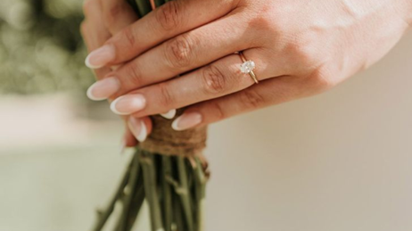 A bride's hands holding a wedding bouquet