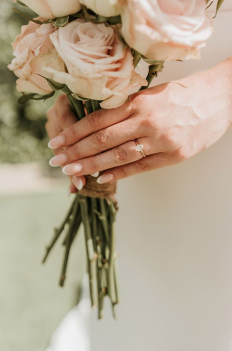 A bride's hands holding a wedding bouquet